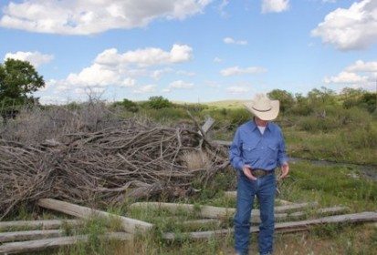 Eric Lawrence shows reporters some of the debris left by the 2010 flood that hit his ranch in the Maple Creek area. (Lisa Guenther photo)