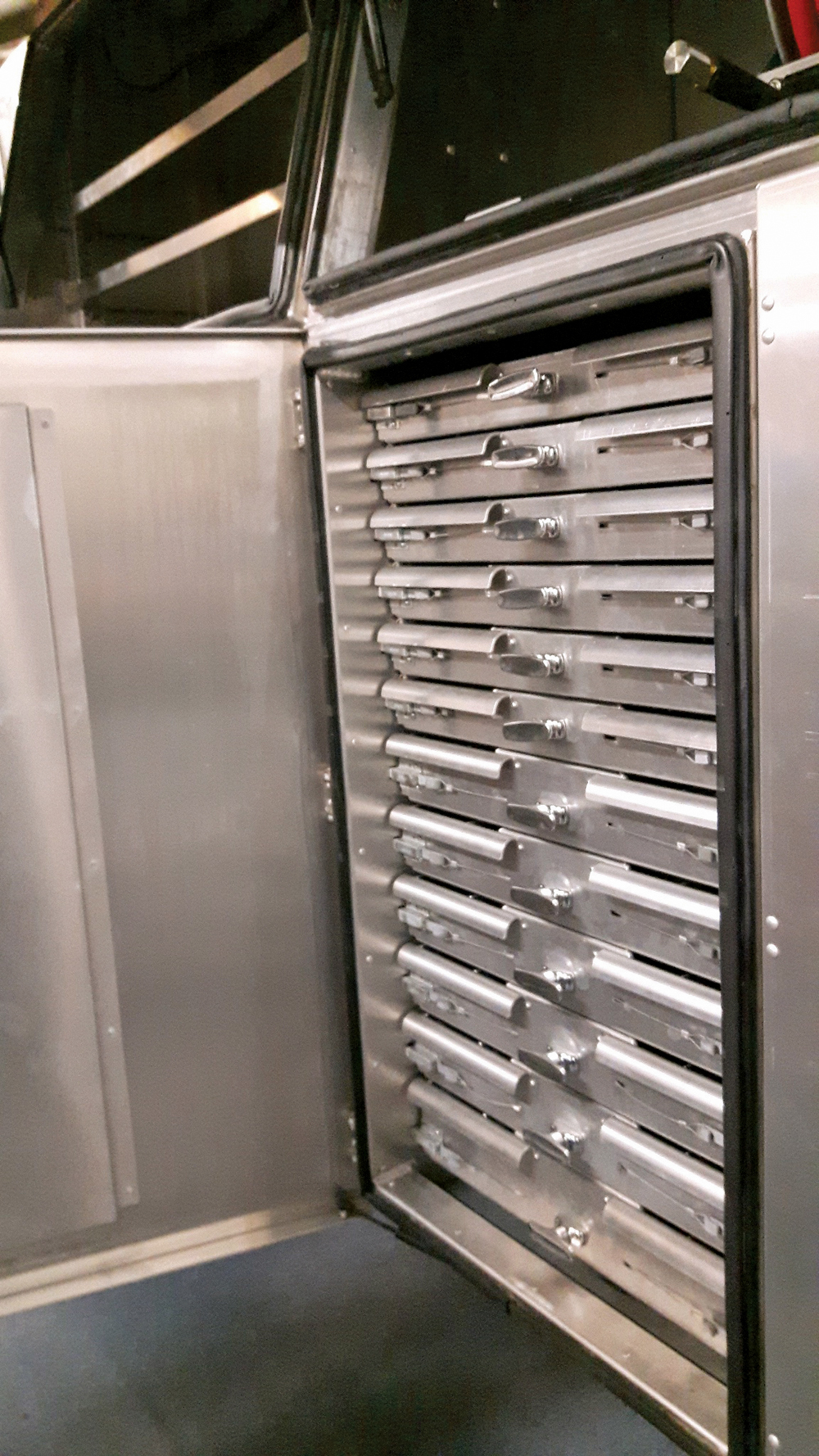 Tool compartments with sliding drawers keep wrenches and equipment safely stored for transport.