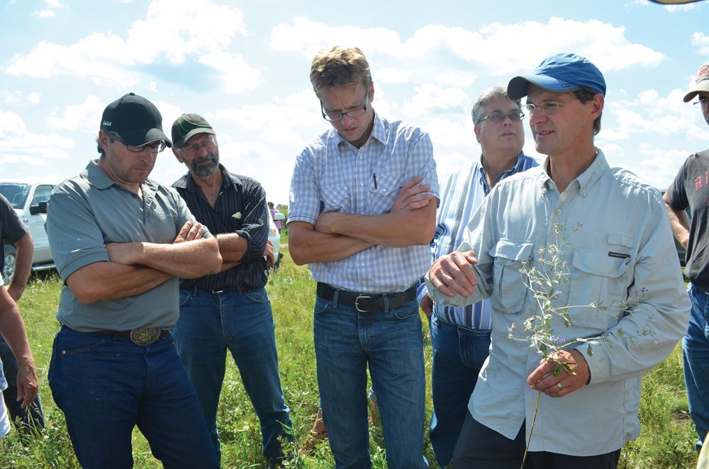 Manitoba grazing club co-ordinator Michael Thiele (r) discusses the importance of ground cover when looking to develop biological activity in soil.