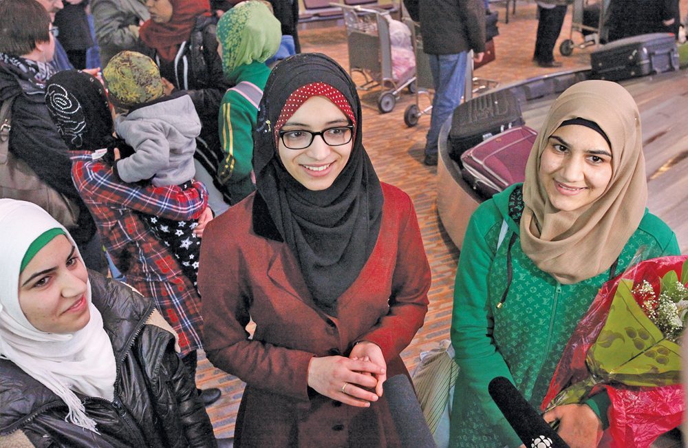 Doaa Abukhousa, (centre) translates for the newly arrived Daas family, who will live in Altona after fleeing their home in Syria more than three years ago.
