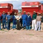 Local farmers in Africa standing beside farm equipment