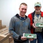 Two Men holding cartons of eggs.
