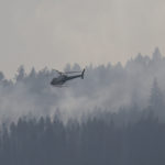 A helicopter flies over a wildfire south west of the town of Cache Creek, British Columbia, Canada July 18, 2017. Residents of the town were forced to evacuate 11 days ago and can now return to their homes. REUTERS/Ben Nelms - RC12041183D0