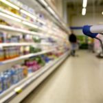 Shopping cart in the refrigerator aisle of the grocery store.