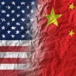 American and Chinese flags on crumpled paper, diplomatic crisis