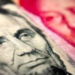 Close-up of an American banknote (showing Lincoln) and a Chinese yuan banknote (Mao Zedong)