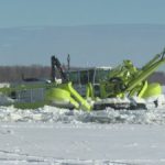 An amphibex lowers its backhoe so it can pull itself on the ice, thereby breaking it. This amphibex is working on the Red River in the RM of St. Clements north of Winnipeg, Man. (RM of St. Clements)