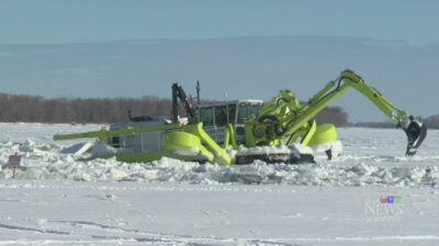 An amphibex lowers its backhoe so it can pull itself on the ice, thereby breaking it. This amphibex is working on the Red River in the RM of St. Clements north of Winnipeg, Man. (RM of St. Clements)
