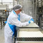 Production worker inside tofu manufacturing facility.