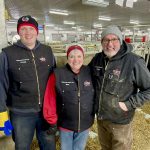 three farmers in a dairy cattle barn