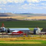 Pastoral scene of farm amid rolling fields.