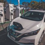 An electric vehicle sits at a charging station.