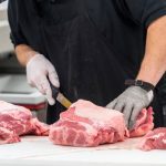 male butcher preparing raw meat