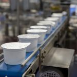 White yogurt packages on a production line at a dairy processor.