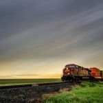 CN train approaches under a cloudy Prairie sky.