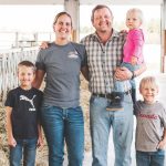 farm family standing in a barn