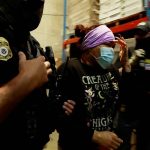 A woman is detained during a raid by U.S. Immigration and Customs Enforcement (ICE) at a Glenn Valley Foods meat production plant in Omaha, Nebraska, U.S. June 10, 2025 in a still image from video.