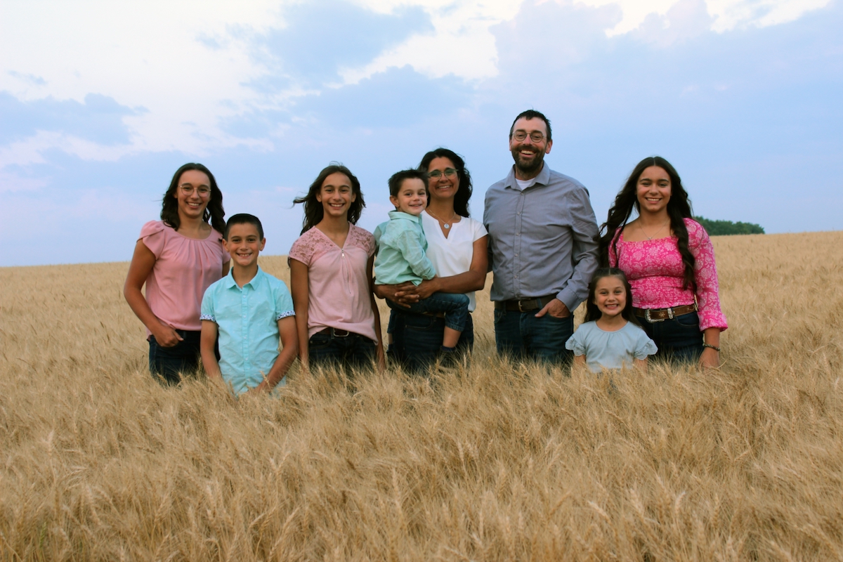 farm family standing in a wheat field