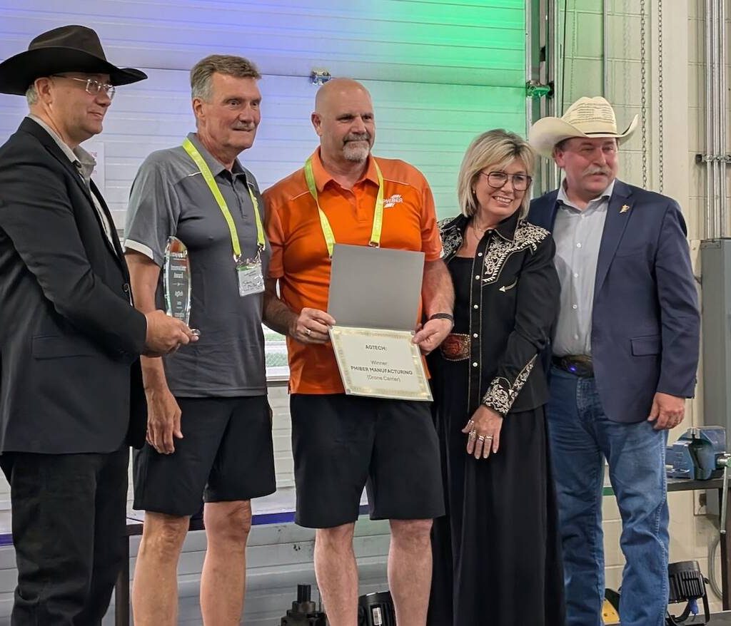 PhiBer Manufacturing won the AgTech innovation award for its drone carrier at the Ag in Motion innovation program, with Saskatchewan Minister of Agriculture Daryl Harrison, right, presenting the award.