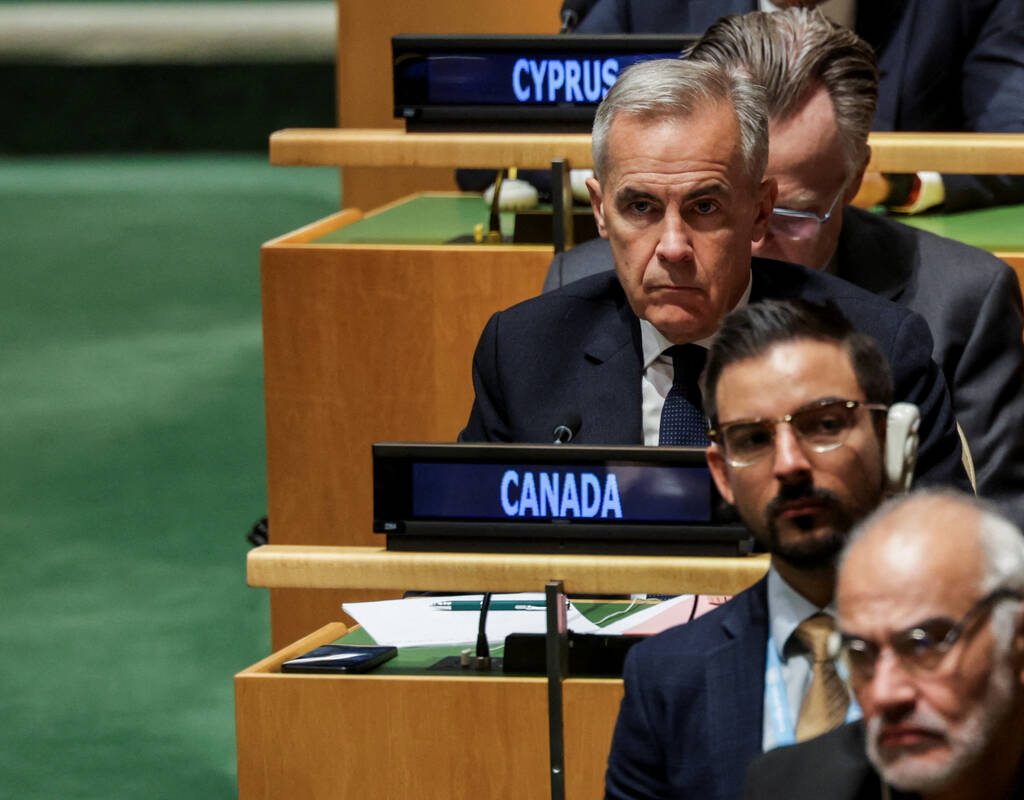 Mark Carney is seen sitting at a desk among delegates from other countries at the U.N. assembly.