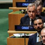 Mark Carney is seen sitting at a desk among delegates from other countries at the U.N. assembly.