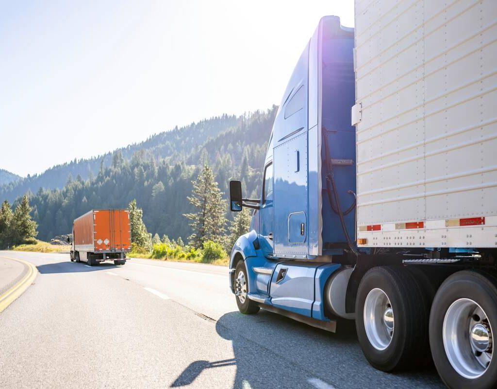 A blue semi truck with a trailor drives on the highway. Photo: Getty Images Plus