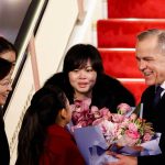 Canada's Prime Minister Mark Carney receives flowers from Lu You Ci, 11, upon his arrival at Beijing Capital International Airport, during the first visit by a Canadian Prime Minister to China since 2017, in Beijing, China January 14, 2026.
