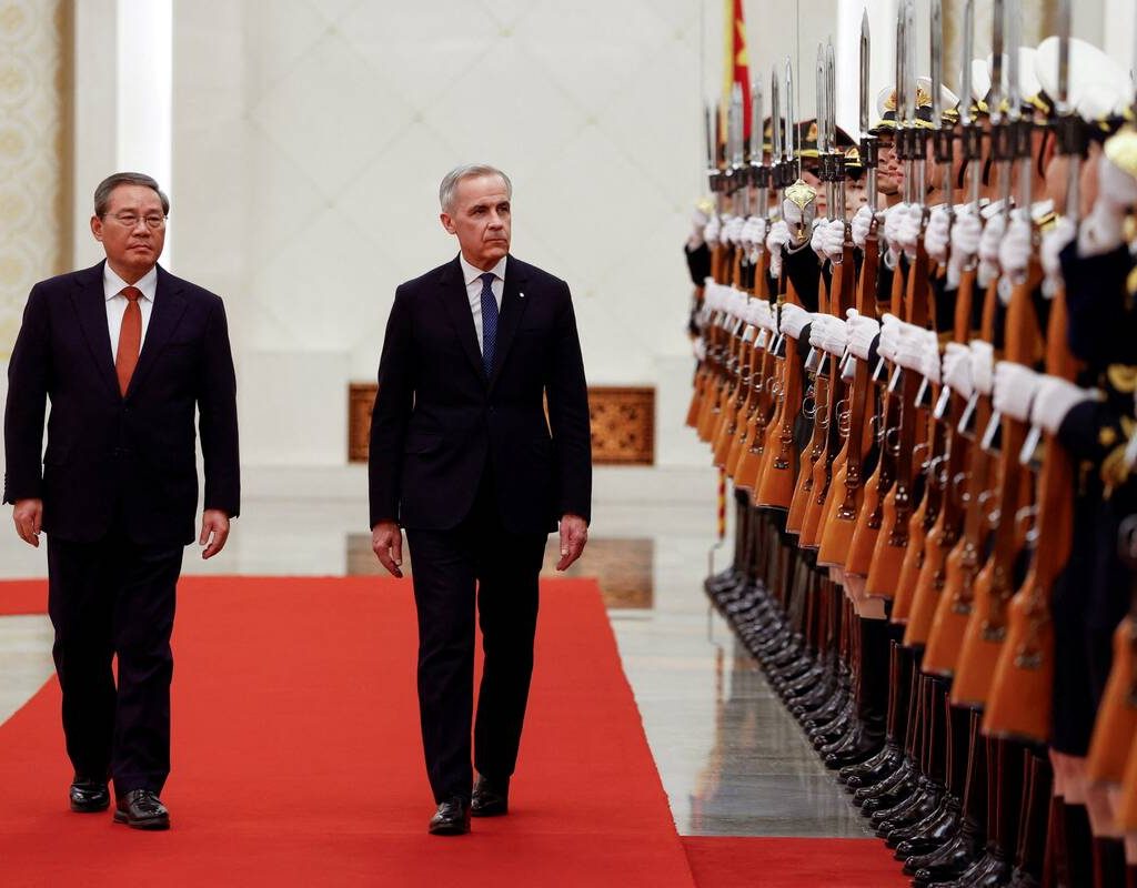 Canada's Prime Minister Mark Carney and China's Premier Li Qiang review the honour guard at an official welcoming ceremony, during the first visit by a Canadian prime minister to China since 2017, at the Great Hall of the People in Beijing, China 