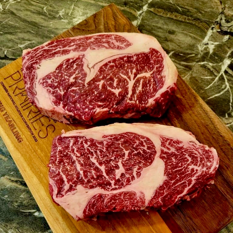 two wagyu steaks on a wood cutting board
