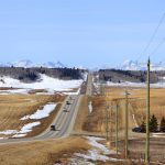 Alberta rural highway between Calgary and Cochrane looking west in early March. Snow covered Rocky Mountains in Distance. Photo: Getty Images Plus