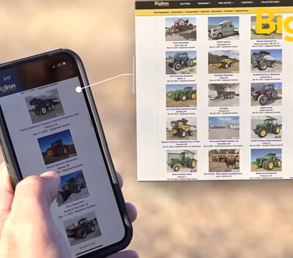 Hand holding a smartphone looking at online farm equipment auction offerings via BigIron. Pic: BigIron video screengrab