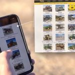 Hand holding a smartphone looking at online farm equipment auction offerings via BigIron. Pic: BigIron video screengrab