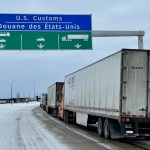 A row of semi trucks approaching the Canada-U.S. border | File photo