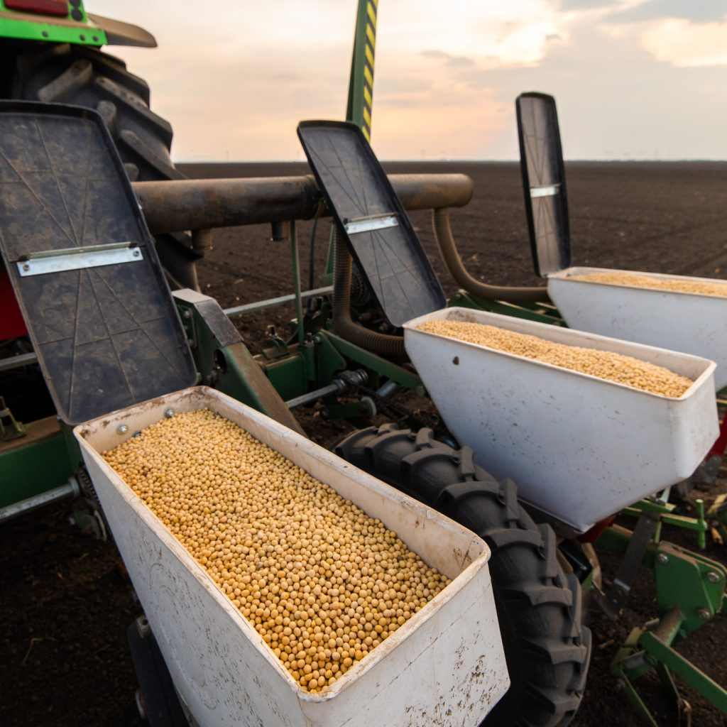 A view of seed bins on a corn planter, which are full of corn seed.