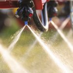 A close-up on the spraying nozzles of an agricultural field sprayer