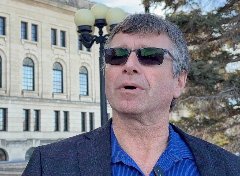 Farmer Norm Hall - a grey haired man wearing a blue shirt, suit coat and sunglasses, is chair of Sask Mustard, stands in front of the Saskatchewan Legislative Building, in Regina, Sask., on March 18, 2026. REUTERS/Ed White.