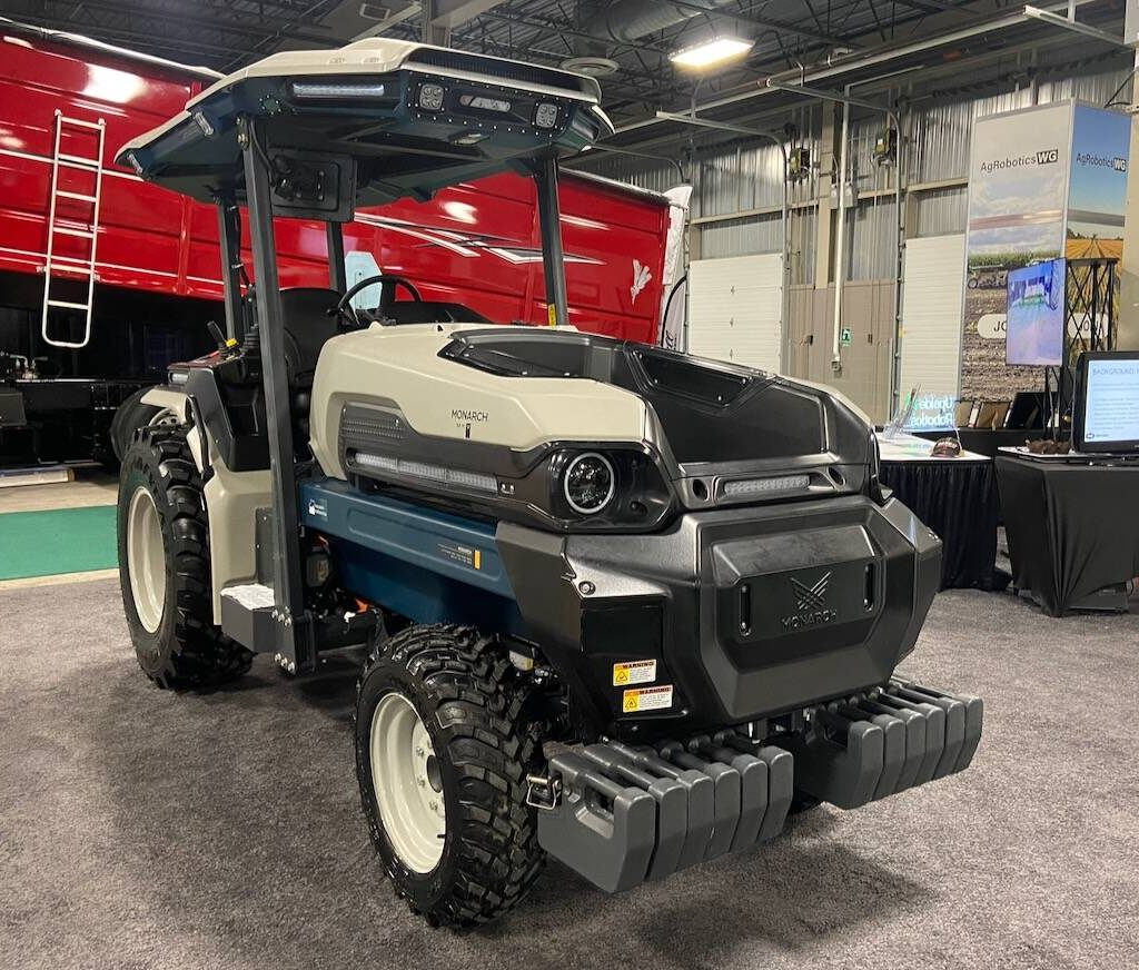 A Monarch electric tractor shown at the 2025 London Farm Show. The tractor is a small utility tractor in black and grey with a roof.