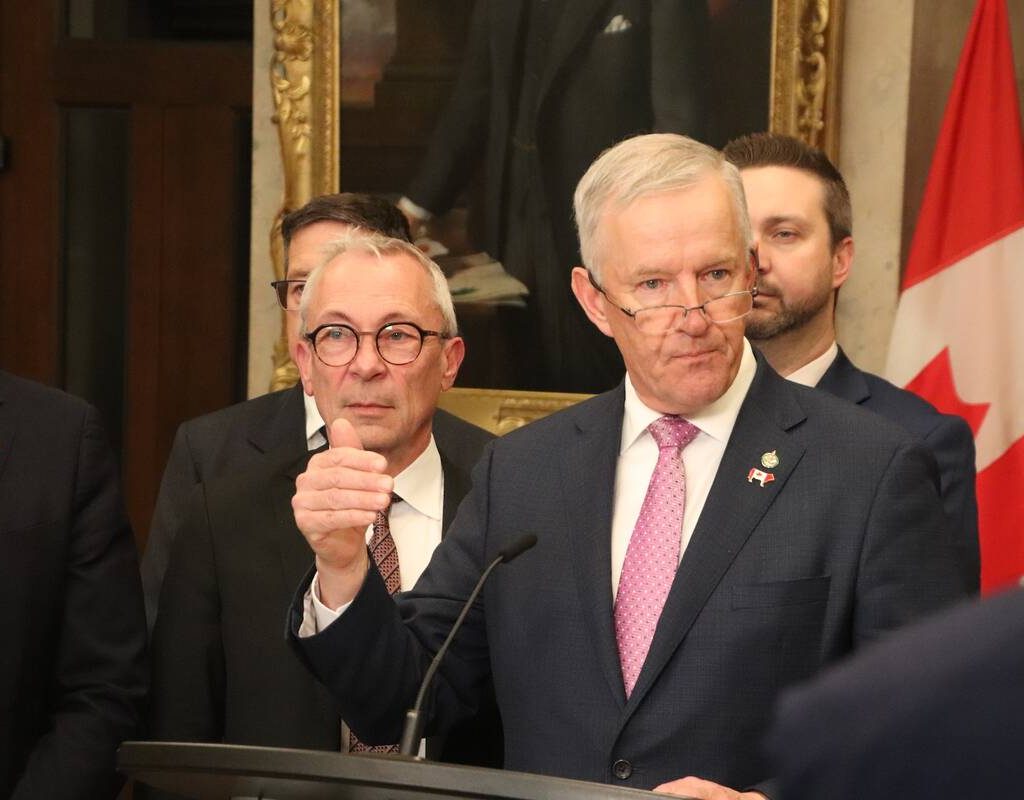 MP David Bexte speaks with reporters in Ottawa on April 15. He is surrounded by supporters.